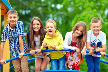 Glückliche Kindergruppe auf einem Klettergerüst